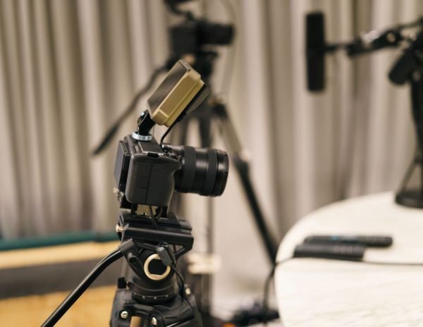 Close-up of a camera and microphone in a professional podcast studio, highlighting equipment setup.